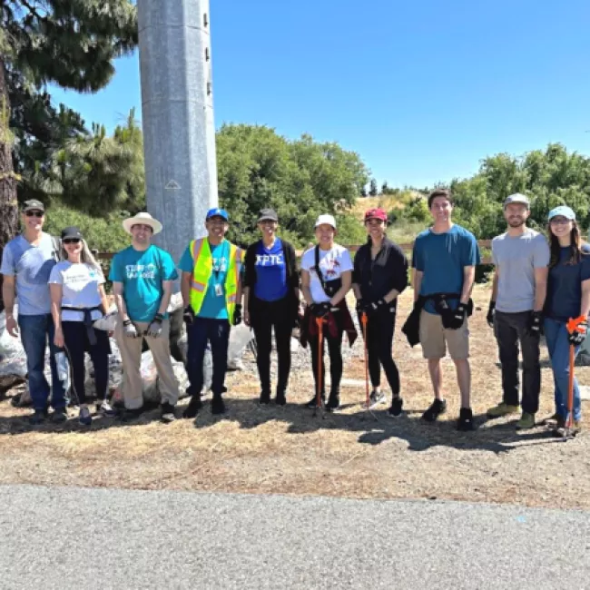 Airport employees and volunteers smile for a photo after cleaning up the river.